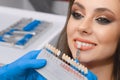 Young patient selects tooth color, crown, veneer, concept of medicine, dentistry and health Royalty Free Stock Photo