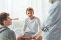 Young patient is sitting cross-legged on a hospital bed during hospitalization