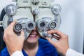 Young patient under going eye test through phoropter Royalty Free Stock Photo