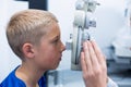 Young patient under going eye test through phoropter Royalty Free Stock Photo