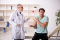 Young male patient visiting old male doctor in vaccination conce Royalty Free Stock Photo