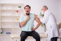 Young male patient visiting old male doctor in vaccination conce Royalty Free Stock Photo