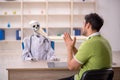 Young male patient visiting skeleton doctor Royalty Free Stock Photo