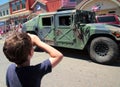 Young patriotic boy salutes military in July 4th parade. Royalty Free Stock Photo