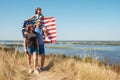 Young patriotic family father with wife and daughter with US American flag in nature. Royalty Free Stock Photo
