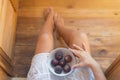 Young peasant girl in a rustic white dress going to eat fresh figs on a wooden terrace Royalty Free Stock Photo