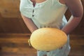 Young peasant girl in a rustic white dress showing fresh melon on a wooden terrace Royalty Free Stock Photo