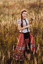 Young peasant woman, dressed in Hungarian national costume, posing over nature background