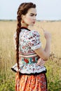 Young peasant woman, dressed in Hungarian national costume, posing over nature background