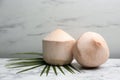 Young peeled coconuts with palm leaf on white marble table Royalty Free Stock Photo