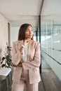 Young pensive business woman in office looking away thinking, vertical. Royalty Free Stock Photo