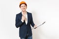 Young pensive businessman in dark suit, protective construction helmet holding clipboard with papers document and pencil Royalty Free Stock Photo