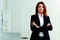 Young pensive businesswoman standing with arms folded Royalty Free Stock Photo