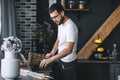 Young pensive caucasian bearded man using a laptop in the kitchen room Royalty Free Stock Photo