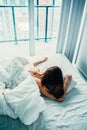 Young pensive Caucasian woman sitting in bed after waking up Royalty Free Stock Photo