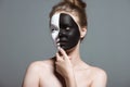 Young pensive girl with creative white and black bodyart on face, Royalty Free Stock Photo