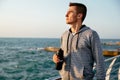 Concentrated sportsman with bottle of water, standing near the sea Royalty Free Stock Photo