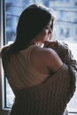 Young pensive woman by the window portrait Royalty Free Stock Photo