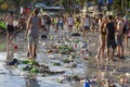 Young peope and consequences of sea water pollution on the Haad Rin beach after the full moon party in island Koh Phangan,