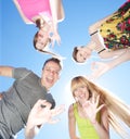 Young people across blue sky Royalty Free Stock Photo