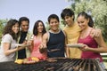 Young people around grill.