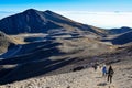 Young people with backpacks hiking in the mountains under the blue sky Royalty Free Stock Photo