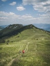 Young people from behind rear view hiking backpacking trekking in the mountains, summer, Slovakia, Velka Fatra