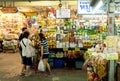 Young people buying exotic food at market with spices, meat, fresh vegetables and sweets