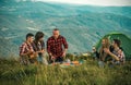 Young people on camping trip. Company of young active friends of boys and girls hiking in mountain countryside. Royalty Free Stock Photo