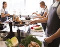 Young people during cooking classes in restaurant kitchen Royalty Free Stock Photo