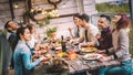 Young people dining and having fun drinking red wine together on balcony rooftop dinner party - Happy friends eating bbq food at Royalty Free Stock Photo