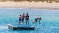 Young people diving off the pontoon at Palm beach, Mangles Bay