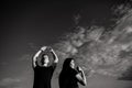 Young people do stretching before training. Sky background, copy space. Black and white photo Royalty Free Stock Photo