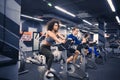 Young people doing exercises on elliptical trainer in gym Royalty Free Stock Photo