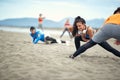 Young people doing stratching exercises on the beach Royalty Free Stock Photo