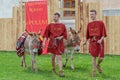 Young people dressed in Roman costumes, with burdened donkeys