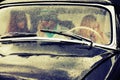 Young people driving retro car in the rain Royalty Free Stock Photo