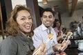 Young People Eating Sushi With Chopsticks In Restaurant