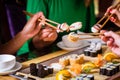 Young people eating sushi in restaurant Royalty Free Stock Photo
