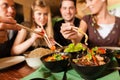 Young people eating in Thai restaurant