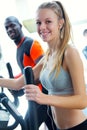 Young people with elliptic machine in the gym.