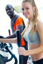 Young people with elliptic machine in the gym.