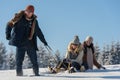 Young people enjoy sunny winter day sledge Royalty Free Stock Photo