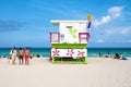 Young people enjoying the beach next to a colorful lifeguard tow Royalty Free Stock Photo