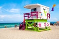 Young people enjoying the beach next to a colorful lifeguard tow Royalty Free Stock Photo