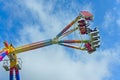 Young people enjoying a daring fun fair ride on a sunny day Royalty Free Stock Photo