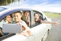 Young people enjoying road trip in the car and making selfie Royalty Free Stock Photo