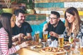 Young people enjoying time together eating burgers and pizza at restaurant