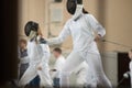 Young people fencers standing in the hall on a fencing tournament and getting ready for the fight