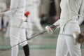 Young people fencers standing in the hall on a fencing tournament. No face shown